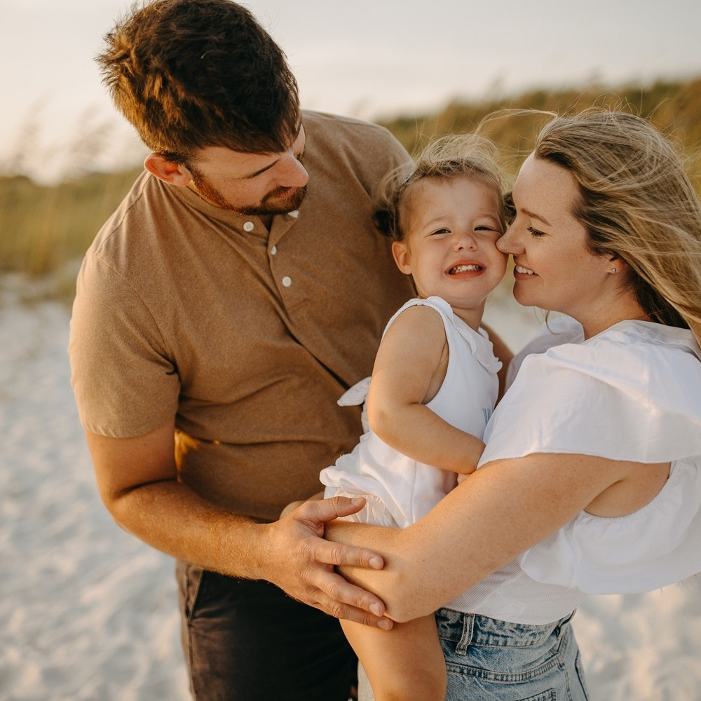 Father holding his young daughter during a family beach photography session in Perdido Key.
